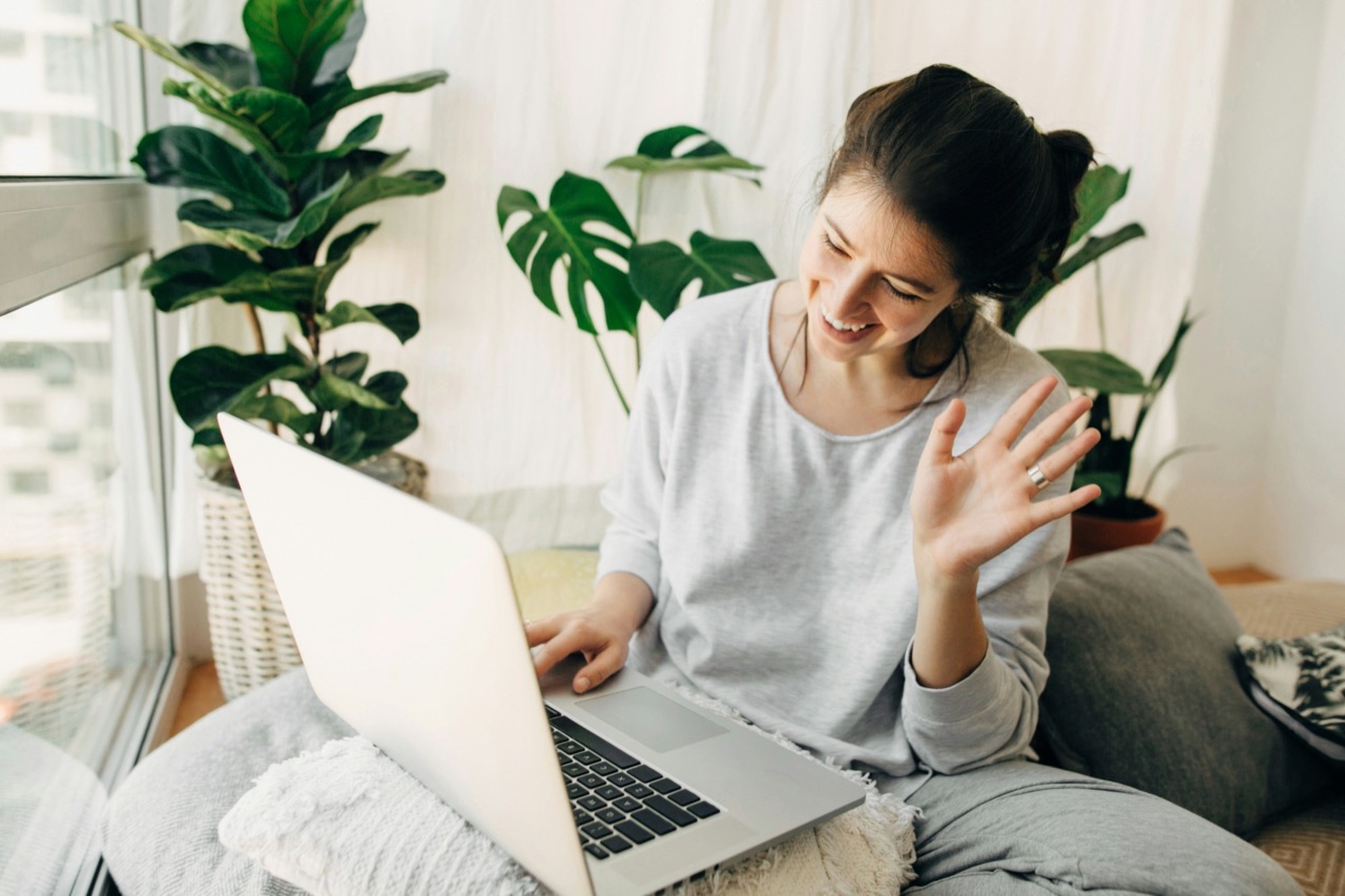 A member waving to her grant coach on a video call